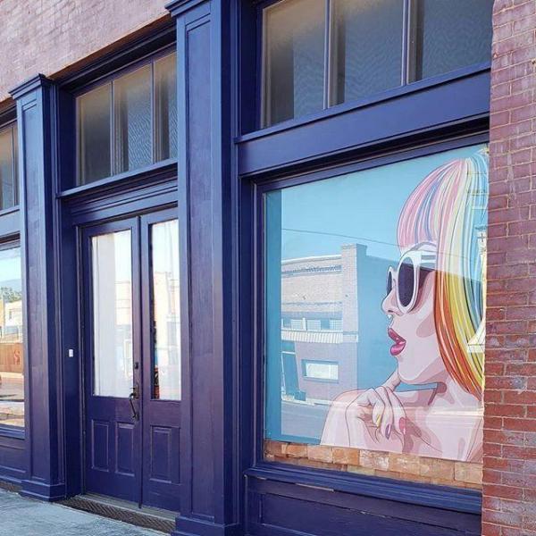 Double Blue door of a building and painting of a woman on the right window
