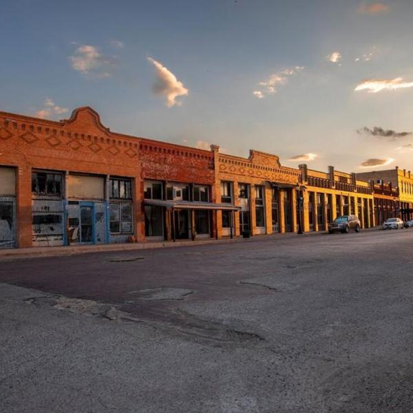 commercial buildings lining a small-town main street at sunset