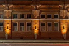 Picture of a red building showing 3 gargoyle on the top