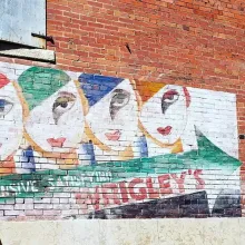 Painting of 4 people wearing white mask, with the word "WRIGLEY'S" at the bottom