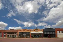 commercial buildings lining a small-town main street on a sunny day