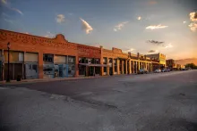 commercial buildings lining a small-town main street at sunset