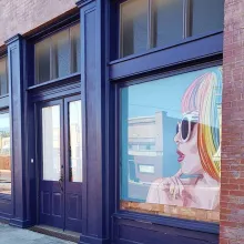 Double Blue door of a building and painting of a woman on the right window